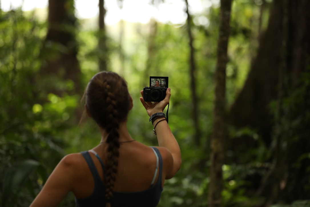Laura filming in dense rainforest during an expedition