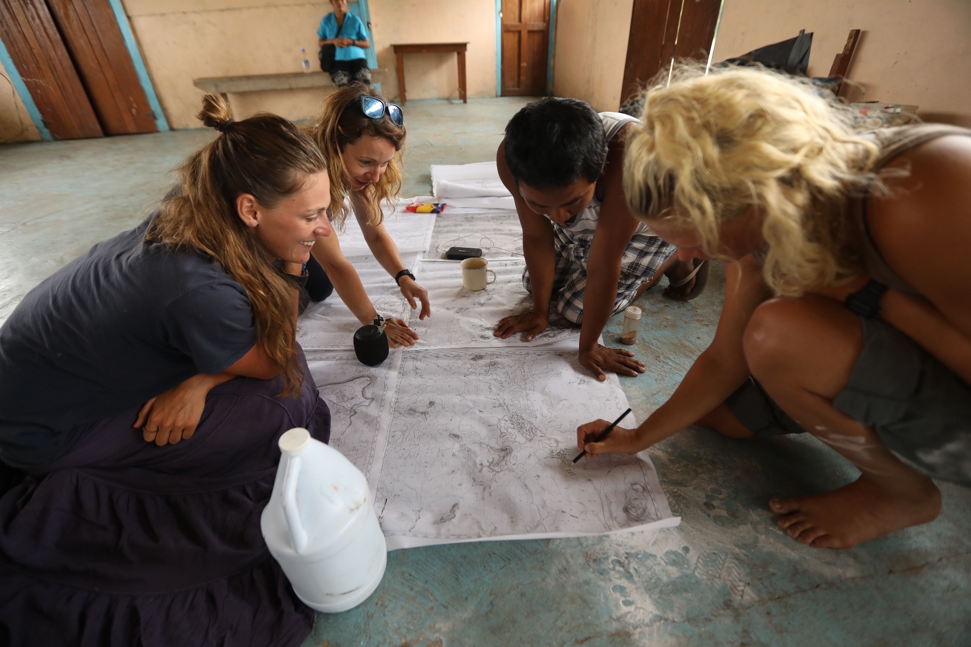 Laura and her team crouched over a large map on the floor, planning the Uganda route