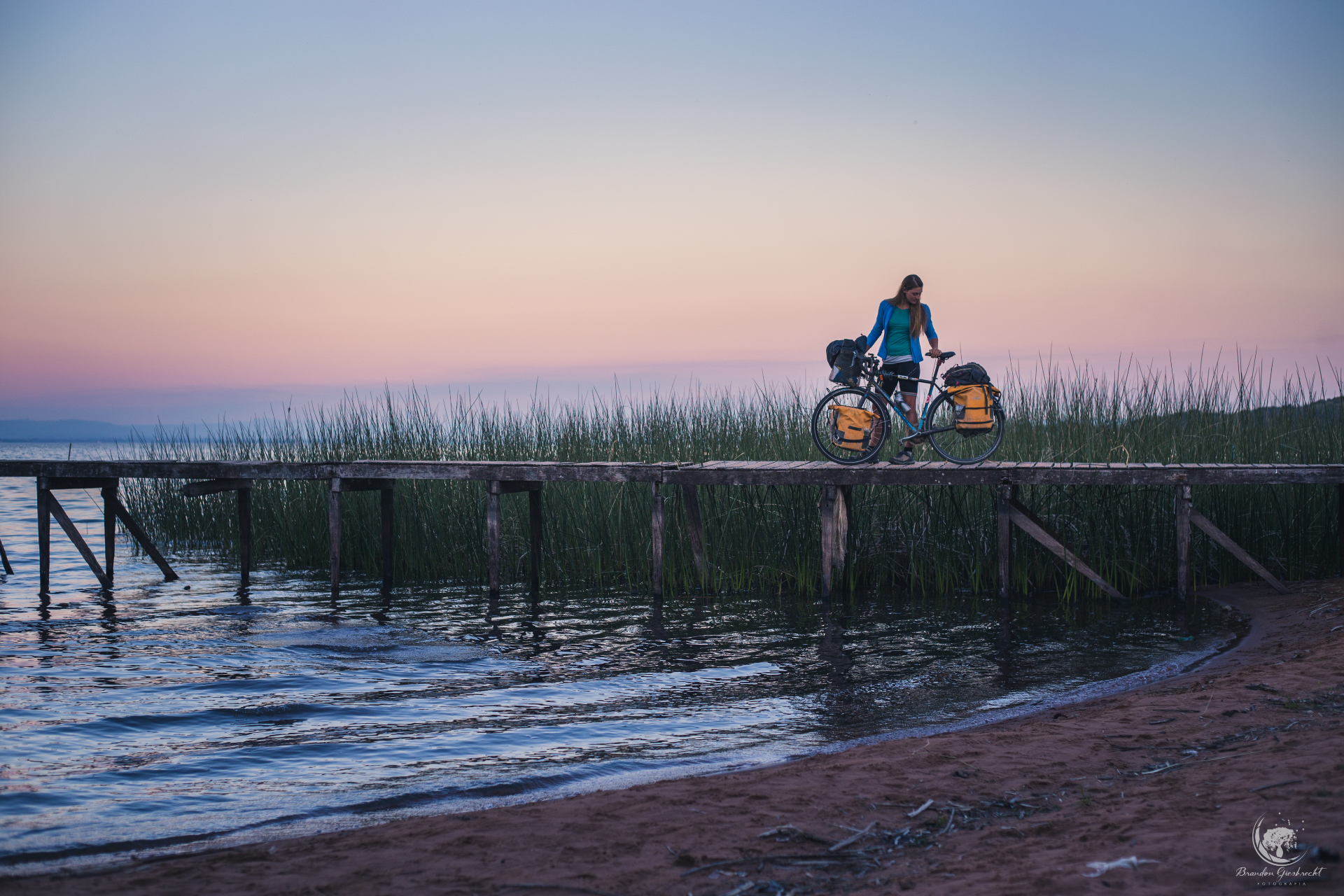 One girl and her bicycle at sunset on a wooden jetty — the real ride that inspired the series