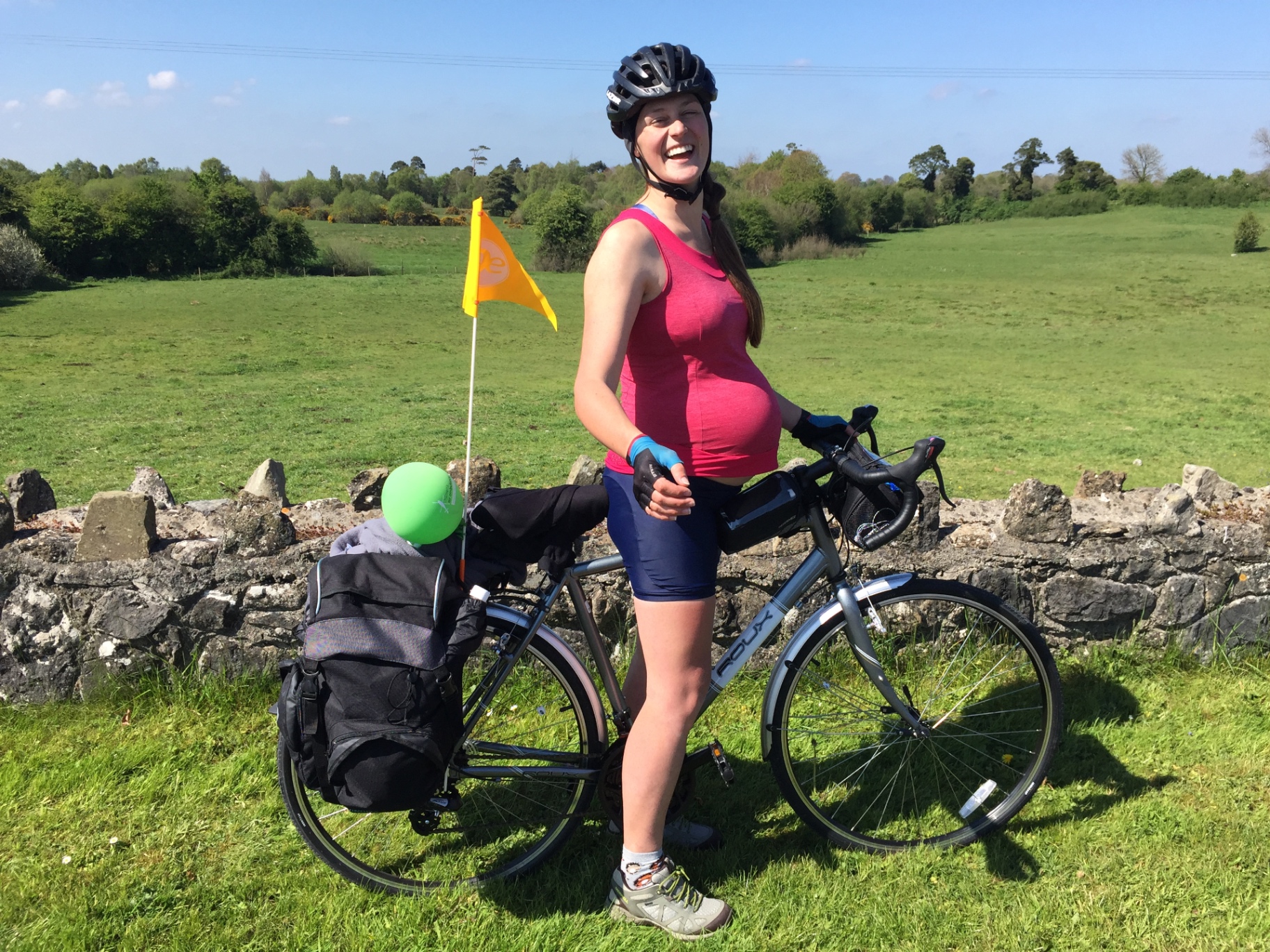 Laura standing with her loaded touring bike while seven months pregnant in Ireland